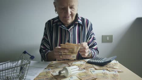 Senior-caucasian-citizen-counting-Euro-bills-in-shopping-cart-office,-paper-cash