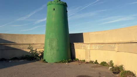 Vorderansicht-Des-Grünen-Leuchtturms-Mit-Einer-Mauer-über-Einer-Landzunge