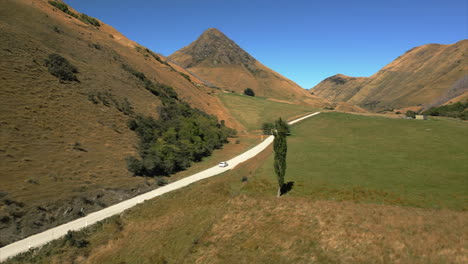 New-Zealand-backcountry-on-the-South-Island-near-Queenstown---car-on-a-countryside-road-aerial-follow