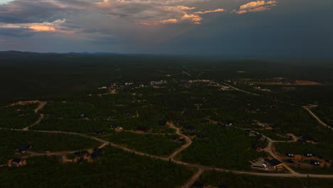 Aerial-overview-of-holiday-cabins-and-the-Saariselka-town,-summer-dusk-in-Lapland