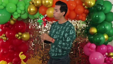 Young-Mexican-Man-Celebrating,-Spinning-Traditional-Windmill-With-Festive-Backdrop