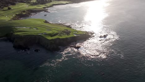 Luftaufnahme-Des-Berühmten-7.-Lochs-Am-Meer-Am-Pebble-Beach-Golf-Links,-Während-Das-Sonnenlicht-Vom-Pazifischen-Ozean-Reflektiert-Wird