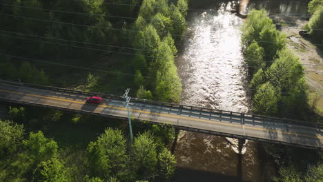 La-Luz-Del-Sol-Brilla-En-El-Río-Wolf-Con-Un-Automóvil-Cruzando-El-Puente-En-Collierville,-Tennessee,-Toma-Aérea