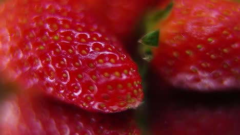 Macro-detailed-video-of-a-pile-of-strawberries,-red-RAW-strawberry,-green-leaf,-tiny-seeds,-on-a-rotating-stand,-smooth-movement,-slow-motion-120fps