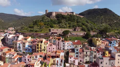 Experience-the-journey-from-the-town-of-Bosa,-Sardinia-to-its-majestic-castle-nestled-amidst-mountains-and-forest-in-captivating-drone-footage,-perfect-for-stock-footage