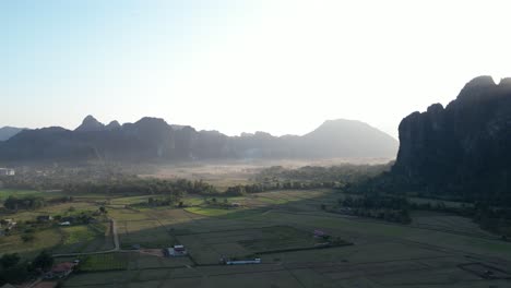 Toma-De-Drones-De-Niebla-Que-Llena-El-Valle-En-Vang-Vieng,-La-Capital-De-Aventuras-De-Laos.