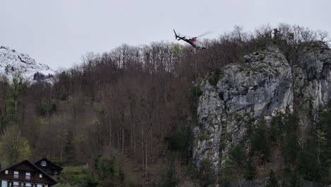 Hubschrauber-Transportieren-Hilfsgüter-über-Die-Schneebedeckten-Weesener-Berge,-Schweiz