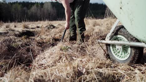 Man-With-Shovel-Digging-Soil-On-Field-For-Garden-Use