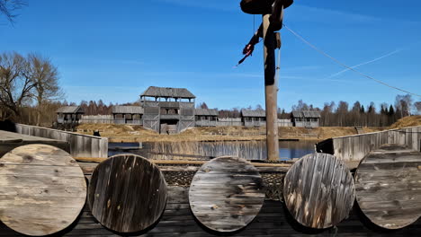 Medieval-Fort-Scenery,-Wooden-Boat,-River-and-Walls-of-Ancient-Village-on-Sunny-Day