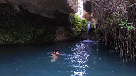 Beautiful-woman-take-bath-in-cavern-full-of-water-idyllic-landscape-called-"Salto-del-Usero"-in-Bullas,-Spain