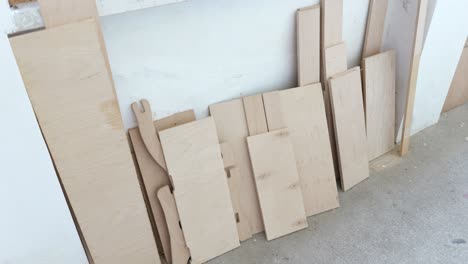 Variety-of-wooden-boards-for-game-pieces-leaning-against-wall-at-game-factory