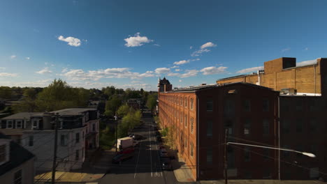 Aerial-fpv-over-american-town-with-solar-panels-on-roof-on-top-of-red-brick-facade