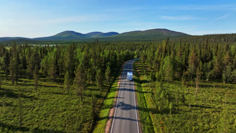 Drone-following-a-camper-approaching-the-Pallastunturi,-summer-day-in-Lapland