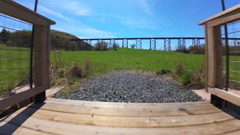 A-low-angle-view-with-an-FPV-drone-flying-from-the-Moodna-Viaduct-in-Salisbury-Mills,-NY-on-a-sunny-day