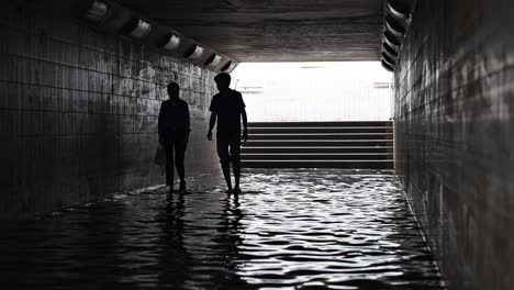 Residents-crossing-a-waterlogged-pedestrian-underpass-after-the-rain-hit-the-UAE-on-May-02,-2024