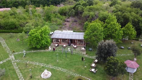 Aerial-view-of-restaurant-building-in-the-Italian-Euganean-hills,-property-with-swimming-pool-and-stone-walkpaths-through-the-lawn