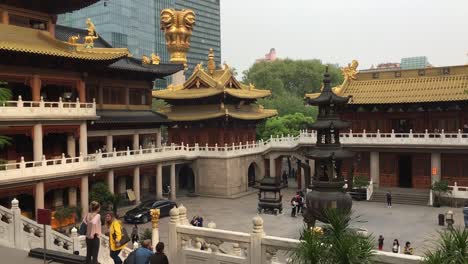 Patio-Del-Templo-Jingan-En-Shanghai,-China-Con-Turistas,-Rascacielos-En-Segundo-Plano.