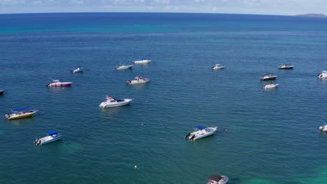 Drone-shot-capturing-boats-anchored-near-the-coastline-in-shallow-waters