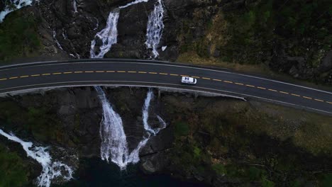 Top-down-view-of-Minivan-across-the-bridge-on-Langfossen-Waterfall,-Norway