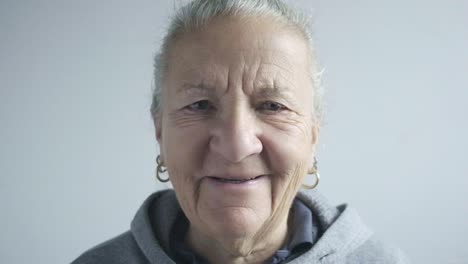 Gesicht-Einer-Frau-Mittleren-Alters,-Nahaufnahme,-Weißes-Haar,-Blaue-Augen,-Porträt,-Lächeln,-Ohrringe-Und-Sportbekleidung,-Studioaufnahme