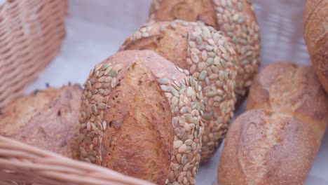 Loaves-of-fresh-seed-bread-in-woven-basket,-close-up