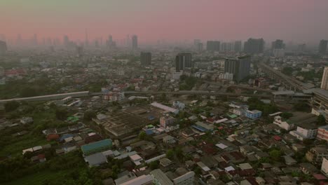 Bangkok-skyline-at-dusk,-warm-hues-over-cityscape,-aerial-view