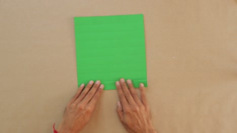 Male-Folds-Green-Paper-into-Traditional-Mexican-Fan