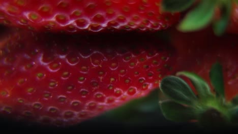 Macro-detailed-video-of-a-pile-of-strawberries,-red-strawberry,-green-leaf,-tiny-seeds,-on-a-rotating-reflection-stand,-smooth-movement,-slow-motion-120fps