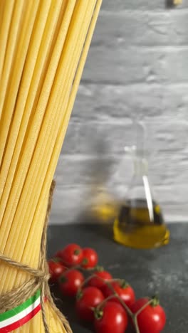 vertical-of-Closeup-shot-italian-spaghetti-pasta-Italy-flag-kitchen-tomato-garlic-basil-rope-tied-view,-kitchen-with-cooking-ingredients-close-up-spinning