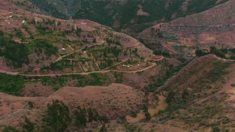 Die-Kirkas-Gemeinde-In-Der-Nähe-Von-Cusco,-Peru,-Luftaufnahme-über-Den-Goldenen-Bergen,-Ausleger-Nach-Unten