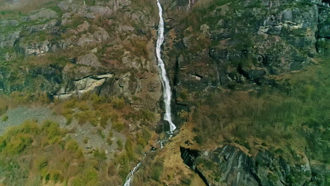 Tall-waterfall-cascading-down-a-Norwegian-mountainside---push-in-aerial