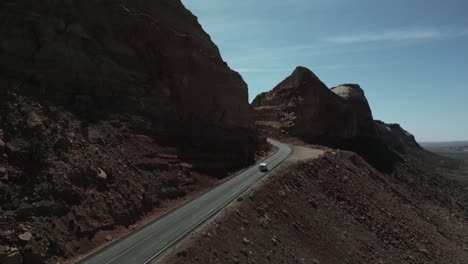 Camper-Van-Driving-On-The-Road-With-Sandstones-Mountains-In-Deserts-Of-Utah,-United-States