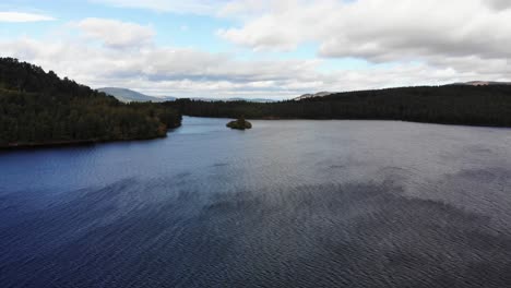 Luftaufnahme-über-Der-Oberfläche-Von-Loch-An-Eilein,-Umgeben-Von-Kiefern-Des-Rothiemurchus-Waldes