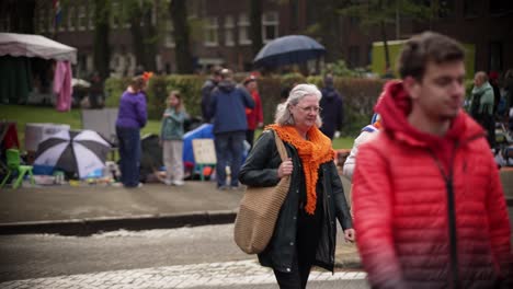 Father-and-son-and-senior-women-crossing-street-during-King's-day-in-Amsterdam-Oud-Zuid