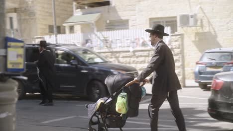 Jewish-man-pushing-a-carriage-in-Jerusalem,-Israel