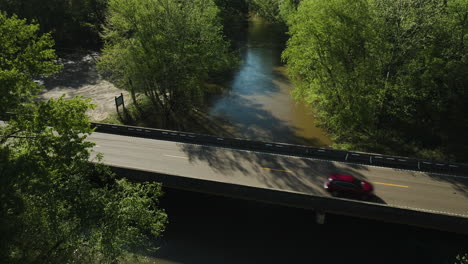 Río-Wolf-Que-Fluye-Bajo-Un-Puente-En-Collierville,-Tennessee,-Rodeado-De-Exuberante-Vegetación,-Vista-Aérea