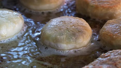 Freshly-made-Xian-Bing-cooking-in-the-pan,-savoury-minced-pork-pastry-deep-fried-until-golden-brown-with-a-crispy-outside,-a-popular-handheld-snack-in-Taiwan,-close-up-shot