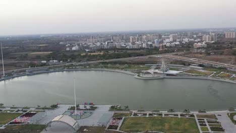 The-drone-camera-is-moving-from-left-to-right-showing-a-residential-area-and-small-bushes-around-the-lake