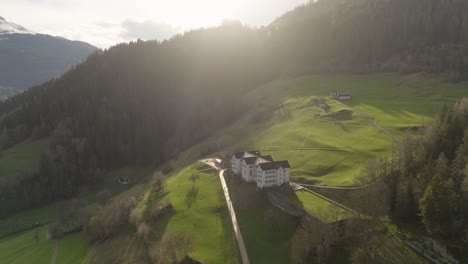 Aerial-of-an-old-building-in-a-swiss-mountain-valley-in-summer-at-sunset