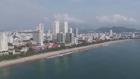 A-picturesque-drone-footage-capturing-the-natural-beauty-of-Nha-Trang's-skyline,-with-clouds-drifting-above-the-city's-architectural-wonders