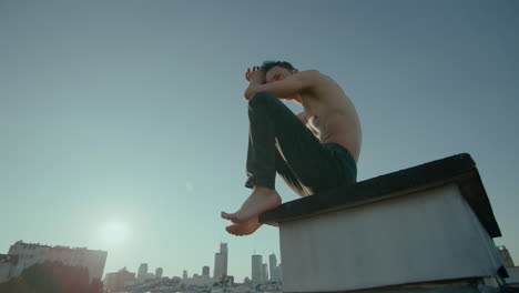 Shirtless-Man-in-Deep-Though-on-Rooftop,-CInematic-Slow-Motion