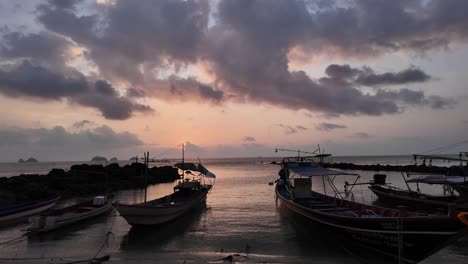 Barcos-De-Pesca-Al-Atardecer-En-Koh-Samui,-Siluetas-Contra-Un-Cielo-Vibrante,-Mar-En-Calma,-Tarde-Tranquila