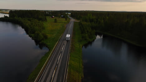 RV-Conduciendo-Sobre-Un-Puente-En-Medio-De-La-Campiña-ártica-De-Laponia---Vista-Aérea