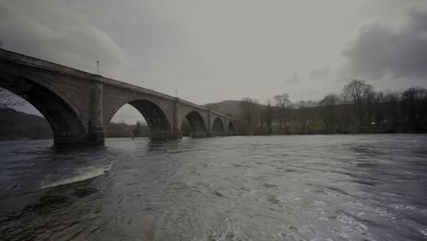 Agua-Que-Fluye-Rápidamente-Bajo-El-Puente-Dunkeld-En-Escocia