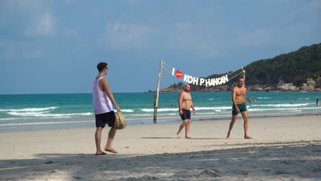 Male-travelers-walking-around-famous-full-moon-party-beach-on-Koh-Pha-Ngan