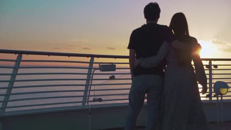 Couple-hugs-and-watch-the-sunset-on-the-sailing-cruise-ship-honeymoon-trip-couple-on-the-sea