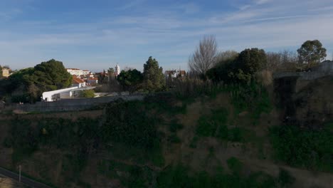 Toma-Aérea-Reveladora-Que-Muestra-La-Ciudad-Histórica-De-Almada-En-Portugal-Con-El-Puerto-Durante-La-Puesta-De-Sol.