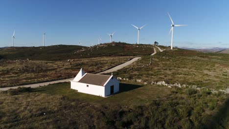 Kirche-In-Den-Bergen-Mit-Windturbinen-Luftbild