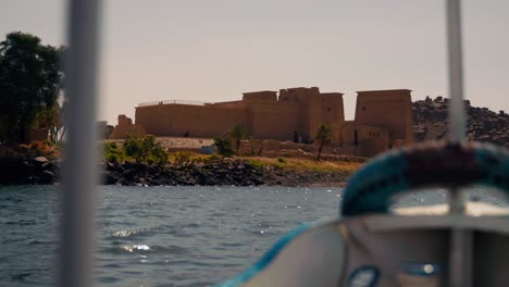 Vista-En-Barco-De-La-Isla-Del-Complejo-Del-Templo-De-Philae-En-La-Presa-De-Asuán-Y-El-Lago-Nasser,-Egipto