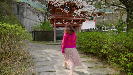Woman-Exploring-The-Temples-At-Tsubosaka-dera-With-Sakura-Trees-In-Bloom-During-Spring-In-Japan